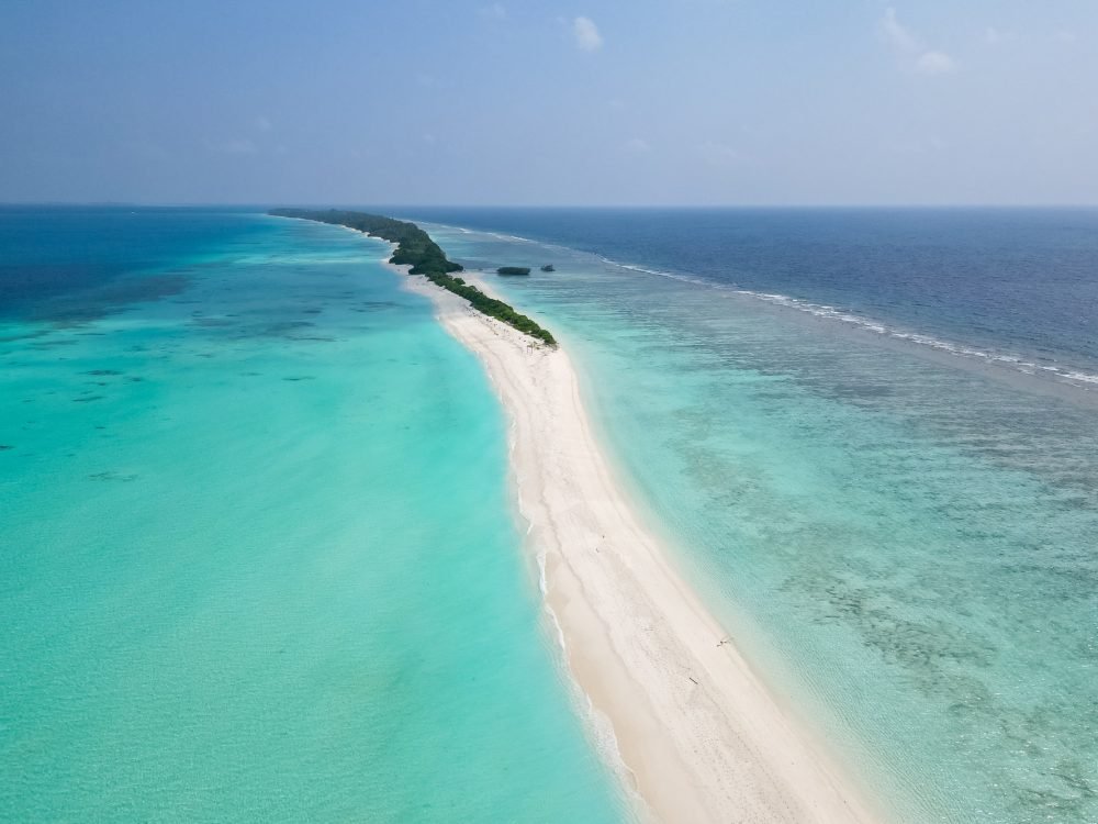 stunning blue ocean and sandy lux hotels on water top drone aeral view Maldives beach copyspace for